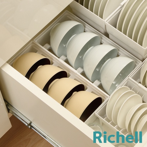 抽屜式餐碗收納架整齊擺放著白色和米色的碗，以及疊放的白色盤子