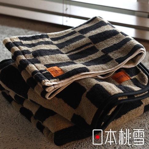 堆疊的格紋毛巾，上面有 ORIRIE 品牌標籤，左下角有日文「日本桃雪」標識
