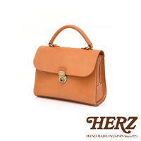 日本HERZ手提包，淺棕色皮革製作，帶有金色鎖扣與拉鍊，簡約經典設計。