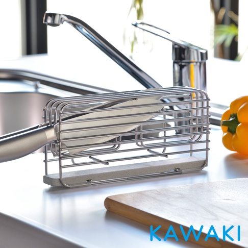 銀色金屬線條構成的珪藻土瀝水刀架，內置一把刀具，底部為淺灰色珪藻土吸水塊，置於廚房水槽旁。
