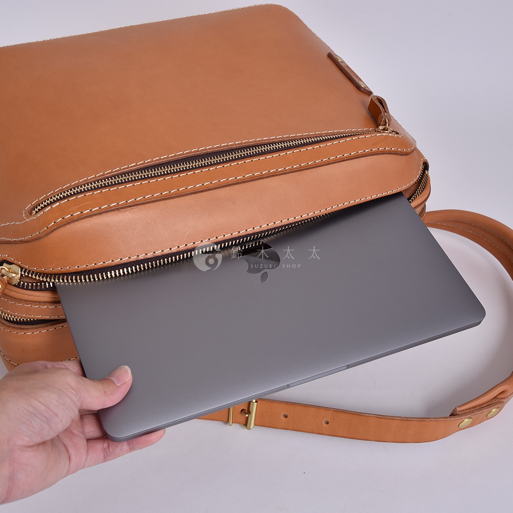 職人手作皮革兩用商務後背包 R-33，採用淺棕色真皮材質，展示包包的拉鍊細節與可放入筆記型電腦的空間，搭配可調整的皮革背帶。