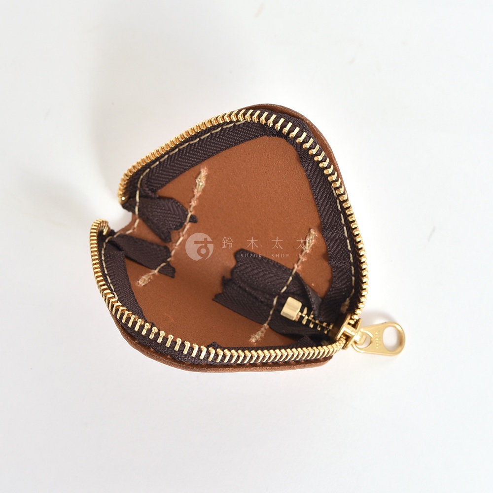 一個打開的日本HERZ手工棕色皮革零錢包，呈現獨特的三角飯糰造型，內部附有金屬拉鍊與棕色織帶細節，背景為純白，中央印有淺色品牌浮水印。