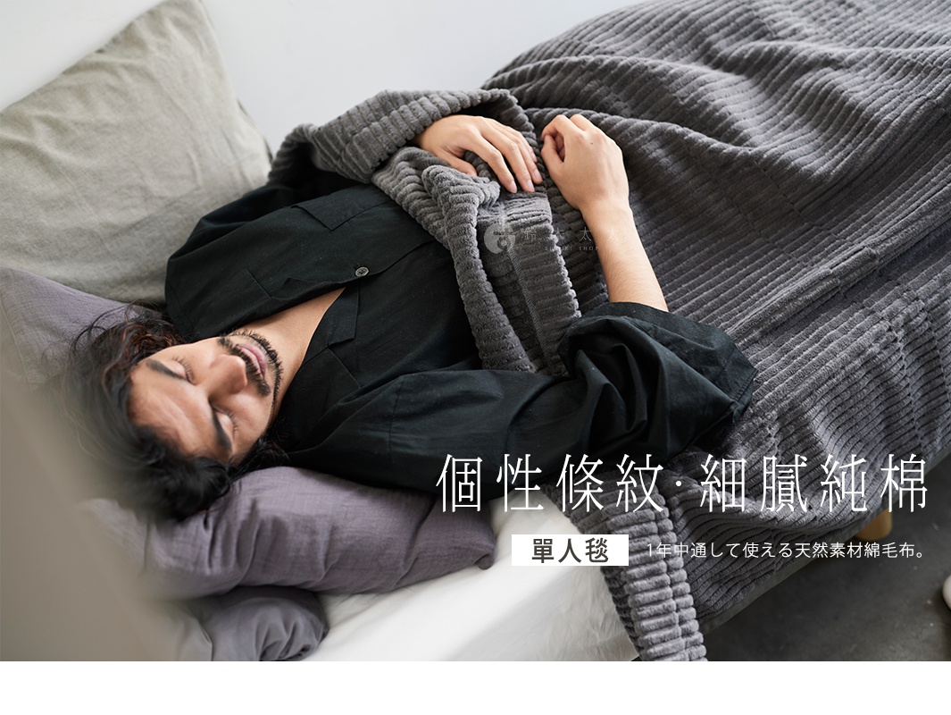 一位男性蓋著灰色GRAU立體直紋純棉微厚單人毯，毯子材質柔軟，有明顯的直向壓紋。