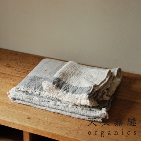 HEATHER有機混紡棉質感流蘇浴巾，呈現柔和的灰白條紋，織紋清晰，邊緣帶有蓬鬆的流蘇裝飾，質感自然。