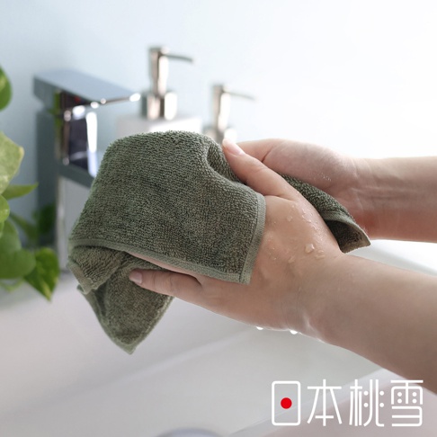 一雙手正用綠色毛巾擦拭，背景有水龍頭。