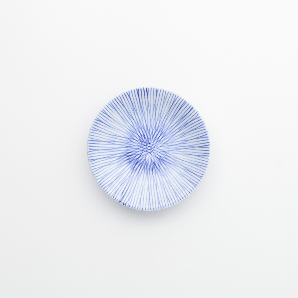 白色陶瓷小豆皿，表面飾有細緻的藍色十草紋，紋路從中心向外輻射。