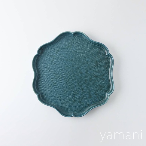 藍綠色美濃燒花型主食盤，表面有細密的紋理，邊緣呈波浪狀，材質為陶瓷。