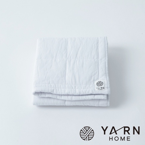 白色UKIHA格紋毛巾，由脫脂棉混紗製成，質地柔軟，帶有品牌標籤。