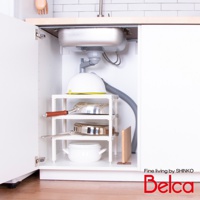 白色三層迷你收納架，架上擺放著鍋子、平底鍋和湯鍋。收納架位於廚房水槽下方，周圍有水管和白色櫥櫃。