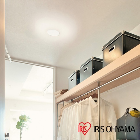 LED小型吸頂燈 SCL20，圓形白色燈罩，安裝於天花板，散發柔和光線。下方為木質層架，擺放三個黑色收納盒，另有衣架懸掛數件白色衣物。