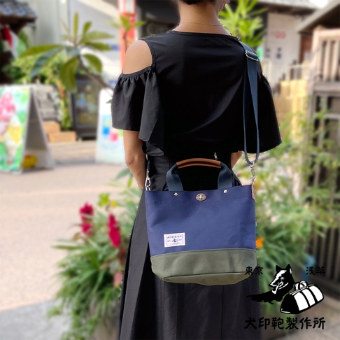 犬印純棉帆布兩用雙色托特包，深藍色與軍綠色拼接，配有皮革提把和可拆卸肩帶。