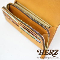 職人手作皮革長夾，淺棕色，拉鍊開合，內部有卡片夾層，可見多張信用卡及紙鈔。