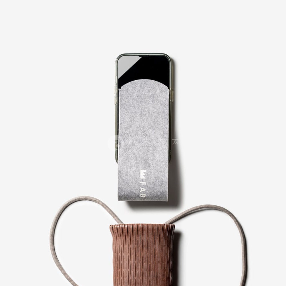 FABRIK 皮革隨形貼合伸縮小包，以其精緻的編織紋理和高品質的皮革材質，呈現出低調奢華的風格，搭配柔軟的絨毛內裡，為您的手機提供全方位的保護，讓您盡顯品味與質感。