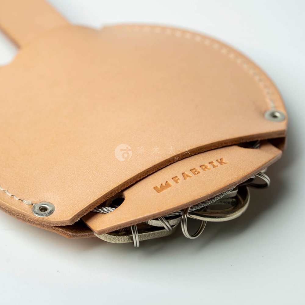 皮革圓形收納鑰匙圈，上面印有 FABRIK 的品牌標誌，可以收納多把金屬鑰匙。