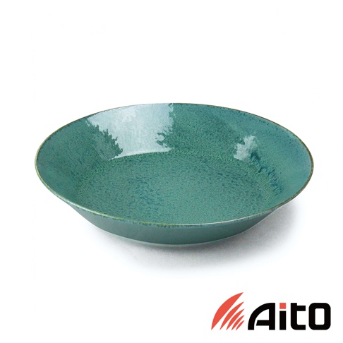 一個綠松石色的陶瓷義大利麵盤，表面帶有紋理，盤緣略微向外翹起。