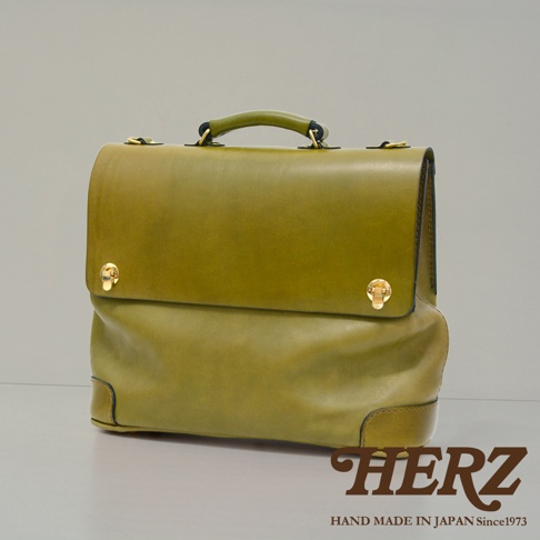 橄欖綠皮革旅行商務兩用波士頓包，帶有金色旋轉鎖扣和手提把。