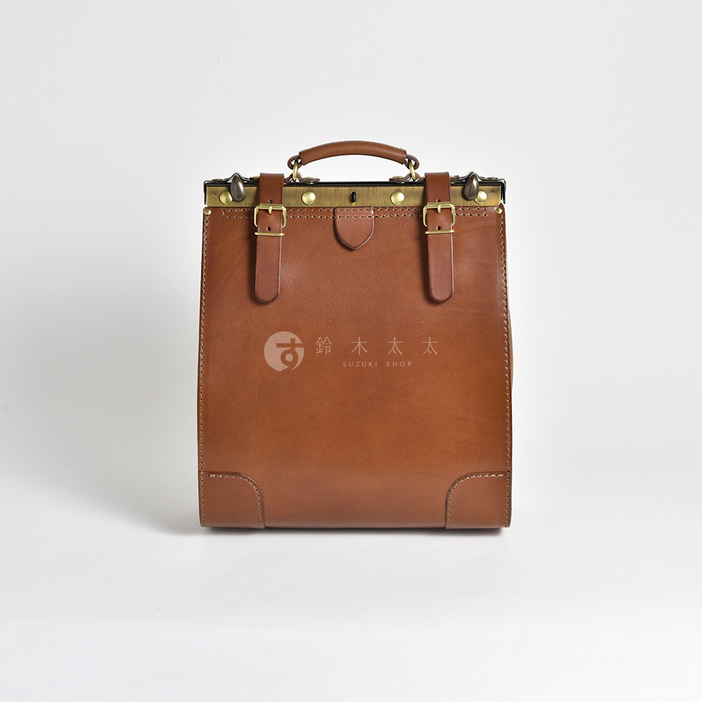 職人手作皮革復古口金後背包，採用棕色皮革製成，配有黃銅色金屬口金、可調節皮帶和搭扣，以及頂部提把，風格經典。