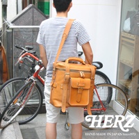 職人手作皮革大型三用旅行後背包，採用棕褐色皮革製成，設計有雙拉鍊主袋、前置翻蓋口袋及金屬釦，並配有可調整的肩帶，展現簡約實用的風格。