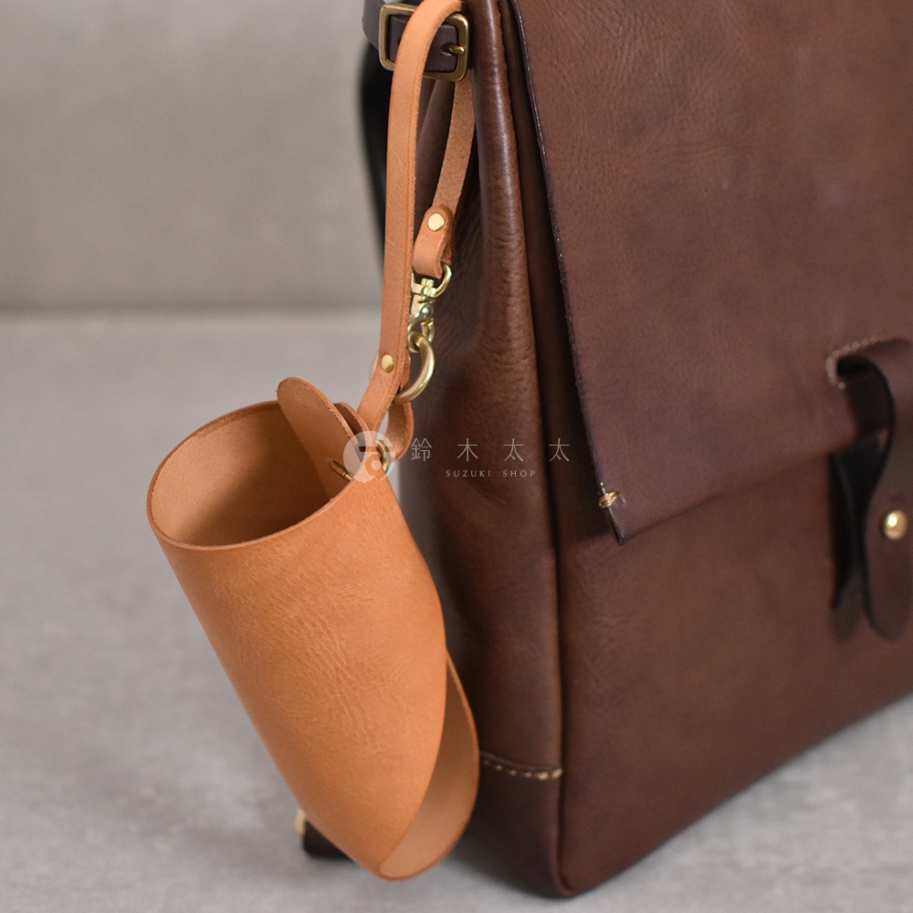 職人手作皮革Organ水壺套，採用天然棕色皮革製成，設計簡約，附有可調節的皮革吊帶和金屬扣環，可掛在背包或皮夾上。