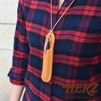 模式B： 一位身穿紅藍格紋襯衫的人，頸部掛著一個淺棕色皮革製的筆套，筆套內插著一支銀色鋼筆。