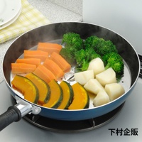 藍色平底鍋內置不鏽鋼蒸盤，盤中擺放著切塊的胡蘿蔔、花椰菜、南瓜片和馬鈴薯塊，蒸氣繚繞。