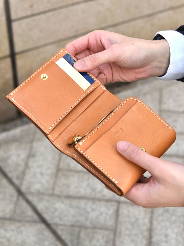 雙折短夾，淺棕色皮革，縫線細緻，內有卡槽，可收納信用卡或名片。