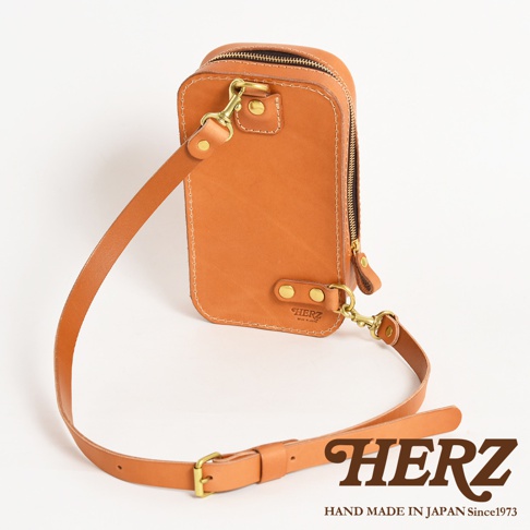 日本HERZ職人手作皮革兩用直立型斜背包，淺棕色皮革材質，附有可拆卸的肩背帶，包包上有HERZ品牌標誌。