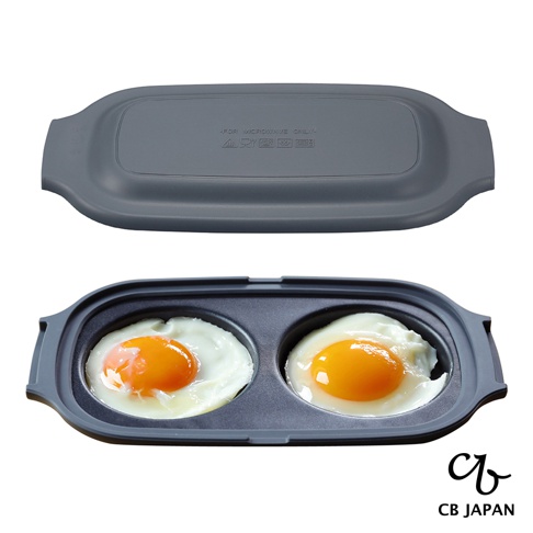 CB JAPAN 微波爐專用燒烤盤，內有兩個已煎好的荷包蛋，附帶灰色蓋子，蓋子上印有「FOR MICROWAVE ONLY」字樣。