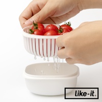 雙層白色塑膠保鮮盒，上層濾籃裝有紅色小番茄，水分正從濾籃滴入下層保鮮盒中。