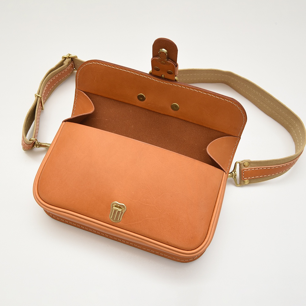職人手作皮革單扣經典斜背包，淺棕色，翻蓋設計，附有金屬鎖扣及可調式帆布斜背帶，皮革材質。