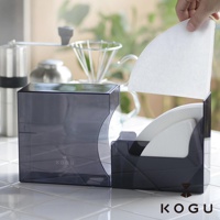 KOGU 珈琲考具推出的日製分隔式咖啡濾紙收納盒，展示透黑設計，左側為較大的濾紙盒，右側則裝有咖啡濾紙，手部正在拿取一張濾紙。