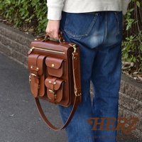 棕色皮革三用後背包，設有頂部提把、可拆卸肩帶、頂部拉鍊主袋，以及前方三個帶有翻蓋和扣環的口袋。