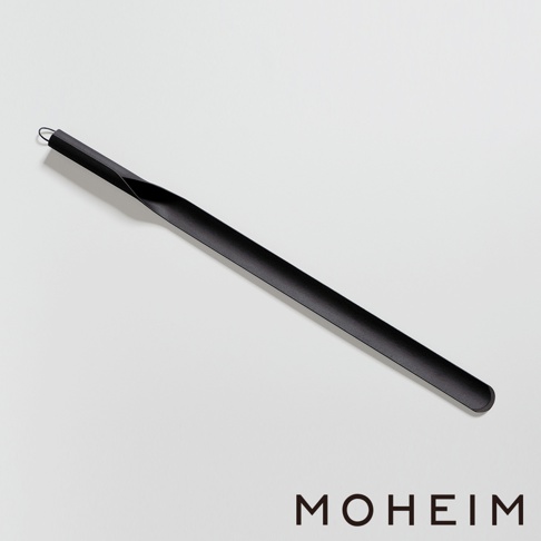 黑色金屬材質的長柄鞋拔，一端有掛環，另一端為弧形設計，方便穿鞋使用。