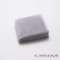 一張疊好的淺灰色毛巾，材質為柔軟的毛圈織物，邊緣有細緻的織紋。