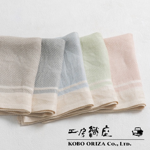 排成一列的 LINETH 純亞麻斜紋萬用廚房拭巾，顏色從左至右分別為淺褐、淺藍、淺綠和淺粉紅。每條拭巾皆有精緻的斜紋編織圖案，並帶有米白色滾邊。