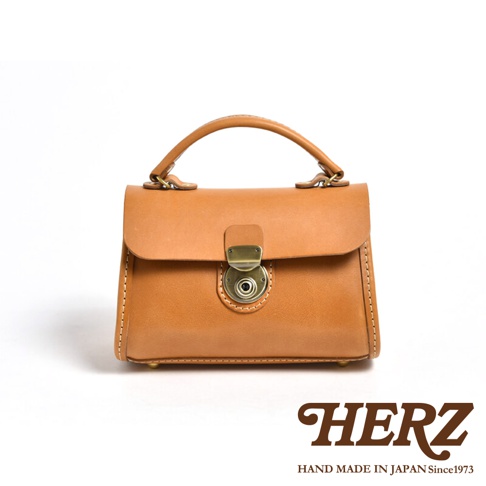 職人手作皮革迷你手提包，經典卡其色，採用光滑皮革材質，配有復古金屬旋轉鎖扣與提把，簡約大方。