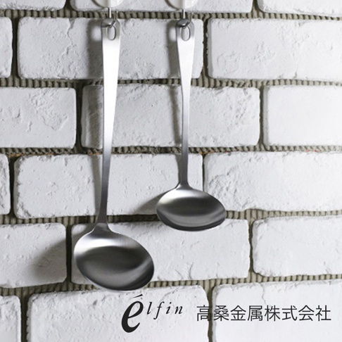 兩個日製不鏽鋼湯杓，湯勺部分為圓弧形，材質為銀色不鏽鋼，皆掛在白色磚牆上。