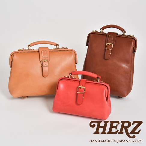 三款不同尺寸的皮革手提包：左為焦糖色，中間為紅色，右後方為深棕色。皆為醫師包款式，具備頂部提把、金屬扣環及皮質束帶。