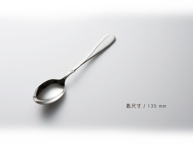 一枝不鏽鋼點心匙，匙柄上有著精緻的雕紋，整體呈現銀色光澤，背景為白色。