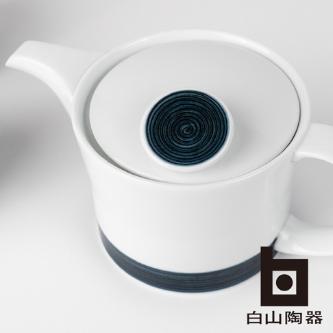 白色陶瓷茶壺，壺蓋中央有深藍色螺旋紋飾，壺身底部有一圈深藍色線條，整體簡潔優雅。