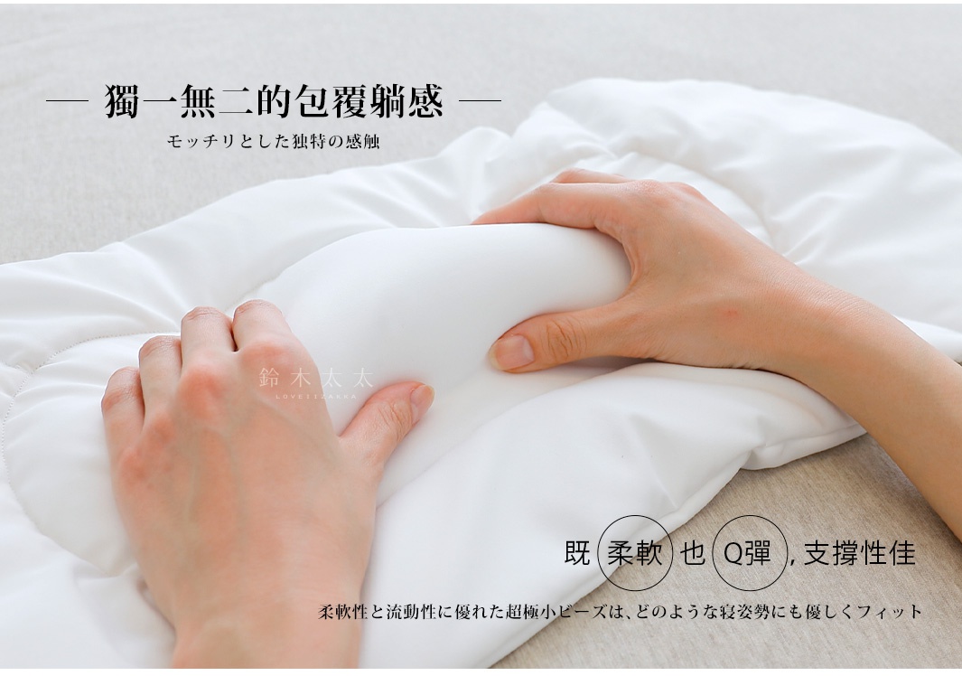 一雙手正在觸碰一個白色的、柔軟的腰枕，材質看起來像是有填充物的布料，枕頭表面有縫線。