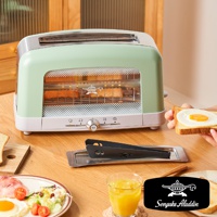 淺綠色與白色機身的烤麵包機，設有透明玻璃視窗，內部可見正在烘烤的吐司。機身前方有旋鈕和按鈕，以及Sengoku Aladdin的品牌標誌。一旁有夾著荷包蛋的吐司和沙拉。