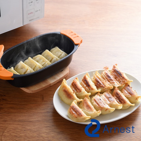 Arnest 多功能微波料理器中烹煮著餃子，盤子裡擺放著煎至金黃的餃子。