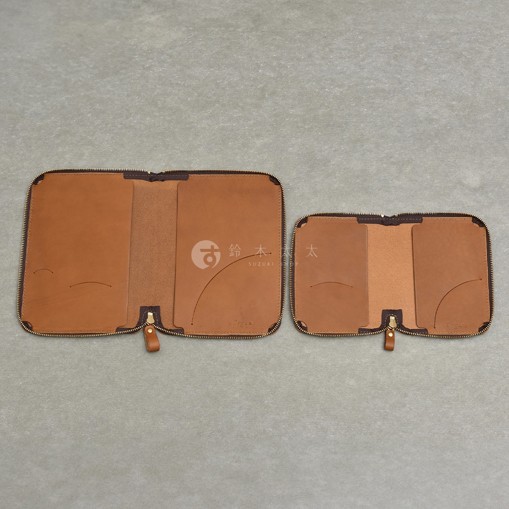 兩款皮革記事本收納包，皆為拉鍊式設計，淺棕色皮革內襯，左側為較大尺寸，右側為較小尺寸，皆有多個卡槽或內袋。