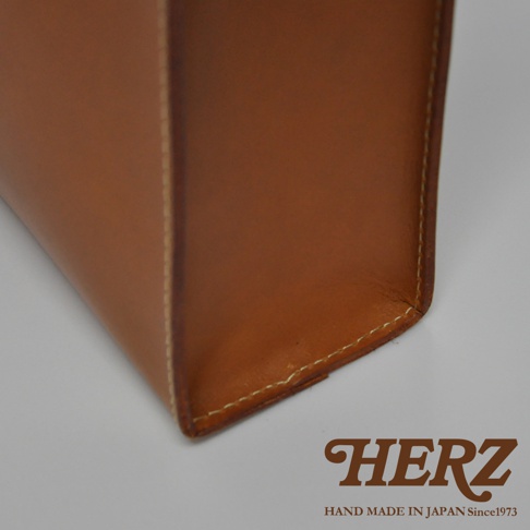 職人手作皮革直式托特包，使用 tan 色皮革製作，縫線清晰，展現皮革質感。