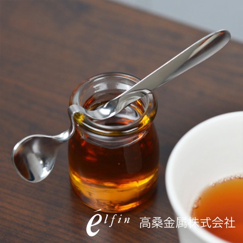 日製不鏽鋼可掛式蜂蜜醬料匙，銀色，光滑鏡面拋光，用於舀取玻璃瓶中的琥珀色蜂蜜。