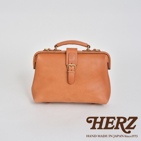 一個棕褐色皮革迷你軟皮杜勒斯包，配有黃銅搭扣和提把。