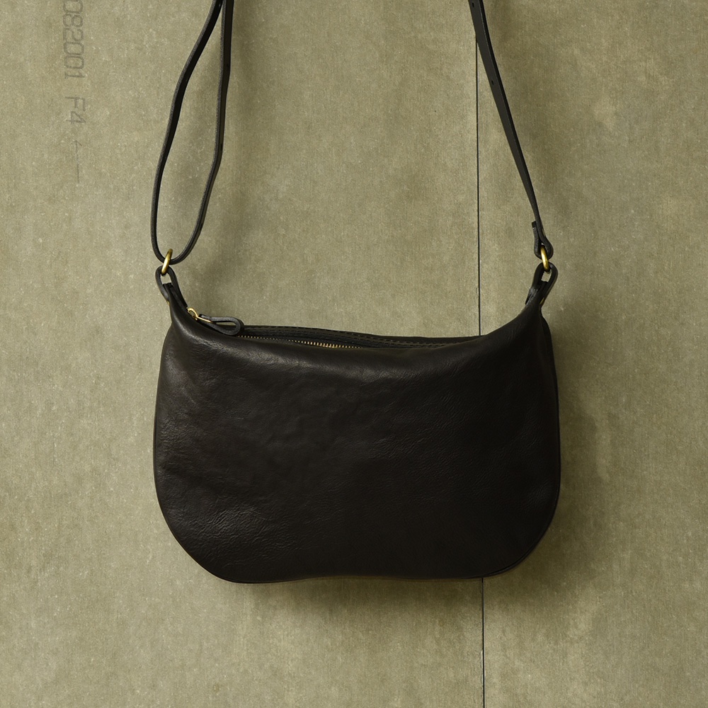 職人手作黑色皮革Organ單肩半月包，包身呈現自然垂墜感，搭配金色拉鍊及可調式皮革揹帶，風格簡約。