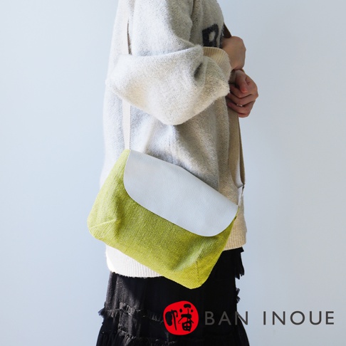 BAN INOUE 品牌字樣旁，一個綠色帆布材質，帶有白色翻蓋的斜背包。
