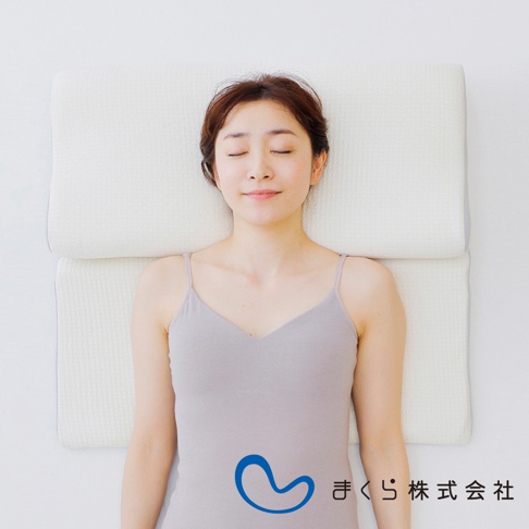 一位女性仰躺在白色與淺灰色的15度半身枕上，枕頭表面有細緻的織紋。